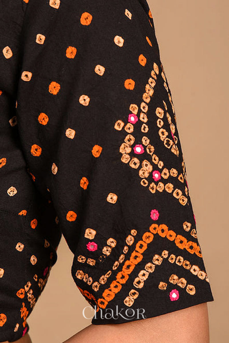 A woman wearing a traditional Black Bandhani Cotton Blouse with intricate mirror embroidered Keri - Paisley motifs and boria fabric buttons.