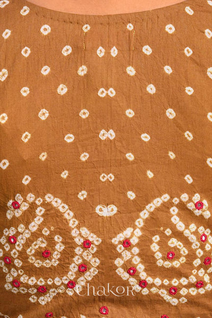 A woman wearing a traditional Mustard Yellow Bandhani Cotton Blouse with intricate mirror embroidered Keri - Paisley motifs and boria fabric buttons.